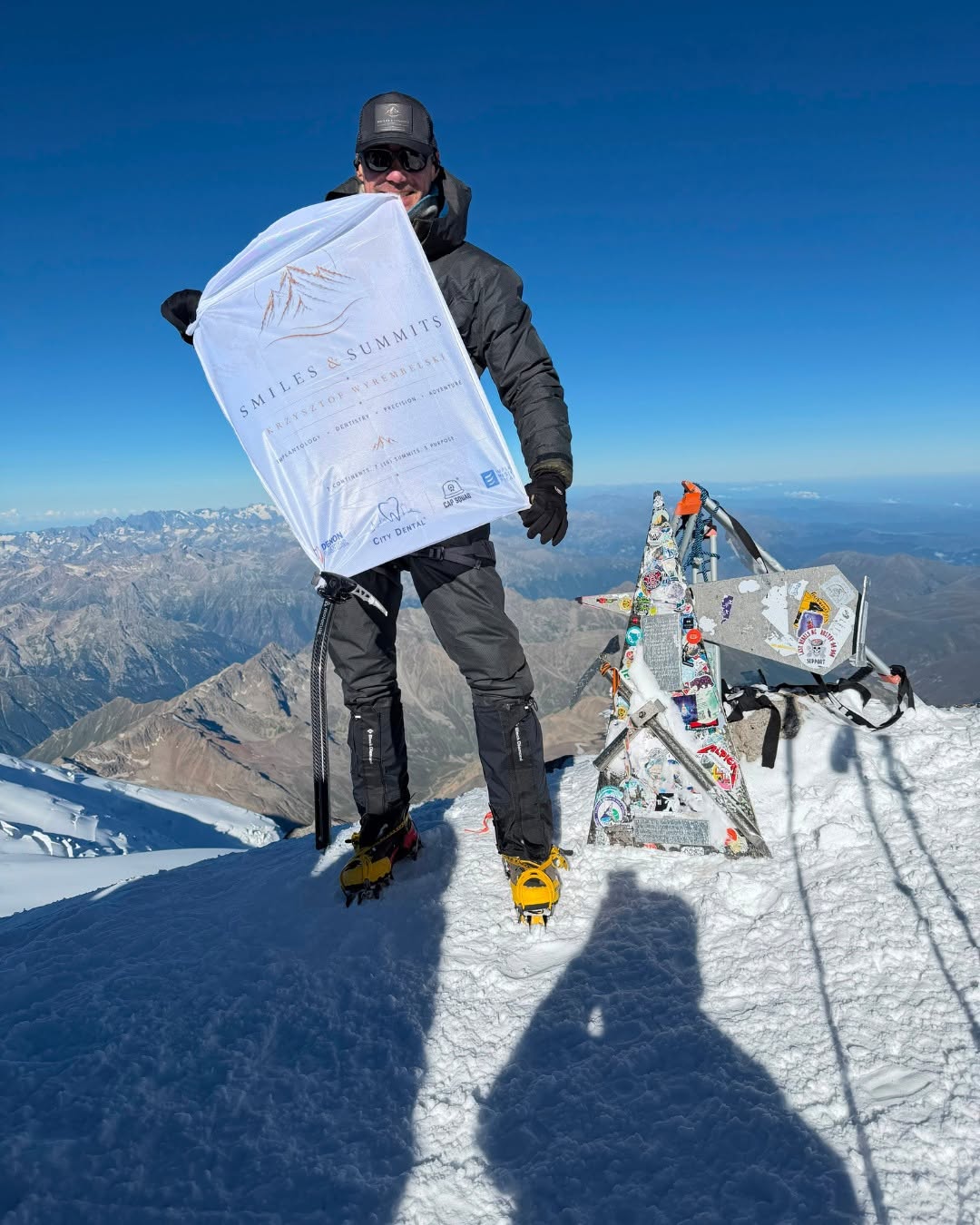 Krzysztof Wyrembelski with the Smiles & Summits flag on the summit of Elbrus